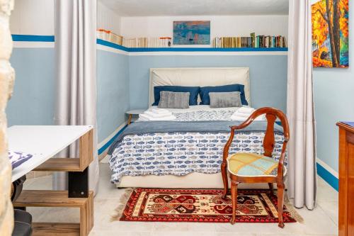 a blue bedroom with a bed and a chair at Villa Letizia Santa Luria Sea View - IUN R9232 in Quartu SantʼElena