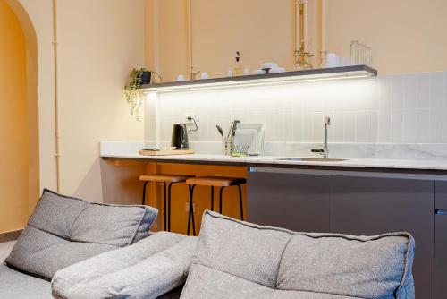 - une cuisine avec 2 chaises à côté d'un évier dans l'établissement grey l studio apartments Downtown Alexandria Menasce House, à Alexandrie