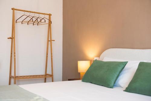 a bedroom with a bed with green and white pillows at A Soqquadro in Bisceglie