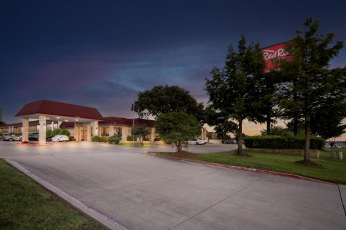 a parking lot at a gas station at night at Red Roof Inn & Conference Center McKinney in McKinney