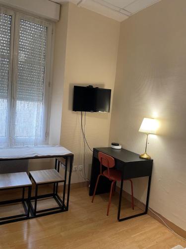 Cette chambre dispose d'un bureau et d'une télévision murale. dans l'établissement Studio Cosy - Rue de la République, à Orléans