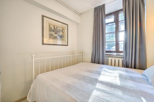 a bedroom with a bed and a window at Elegant apartment in Old town Vilnius SELF CHECK IN 24x7 by H&H in Vilnius