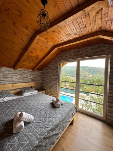 Un dormitorio con una cama y una ventana grande. en Villa Paradise, en Banja Luka