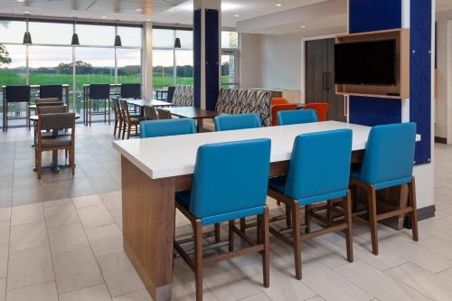 a dining room with blue chairs and a large table at Holiday Inn Express & Suites Reedsburg - Dells Area by IHG in Reedsburg
