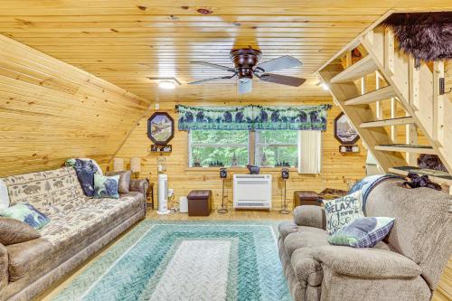 a living room with two couches and a ceiling fan at Carrollton Cabin with Patio and Fire Pit! in Carrollton