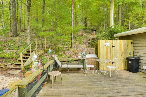 a patio with a table and chairs on a wooden deck at Carrollton Cabin with Patio and Fire Pit! in Carrollton