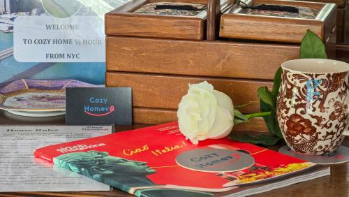 a table with a book and a vase and a flower at Cozy Homeva Battle Hill WP in White Plains