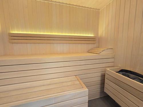 a sauna with wooden shelves and lights in it at Ferienappartment Nordseenixe in Norden