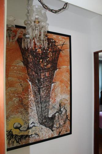 a painting hanging on a wall with a chandelier at CAJOMA Villa in San Ignacio