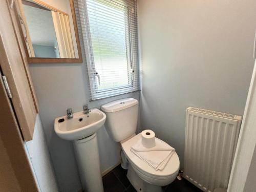 a small bathroom with a toilet and a sink at 2 Bedroom Caravan NV13, Lower Hyde, Shanklin, Isle of Wight in Shanklin