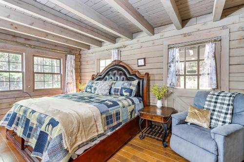Un dormitorio con una cama y una silla y ventanas. en Ellijay Getaway Fire Pit and Hot Tub, en Ellijay