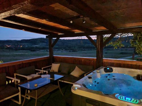 a jacuzzi tub on a deck with a table and chairs at Green House in Vrbovo