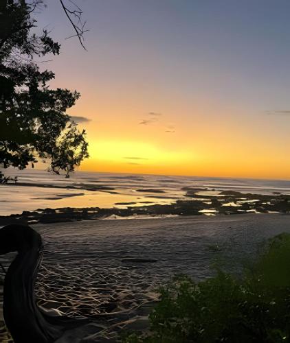 a sunset on a beach with the ocean at Minutes away to the beach ¨Playa Blanca¨ in Paraíso