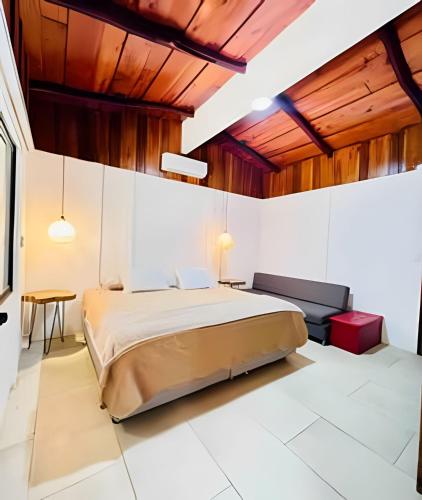 a bedroom with a large bed and wooden ceilings at Minutes away to the beach ¨Playa Blanca¨ in Paraíso