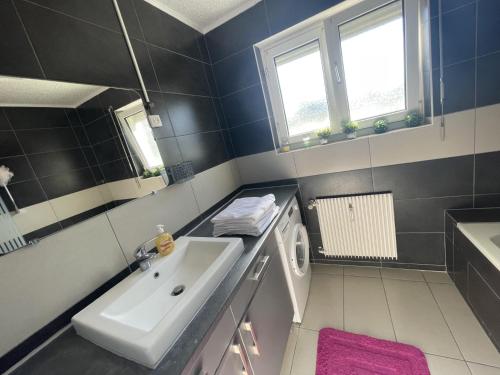 une salle de bain avec un lavabo et une machine à laver dans l'établissement APPARTAMENT 85m2 A 5KM DE BASEL AU 1ERE ETAGE DANS UN CARTIER TRES CALME, à Huningue