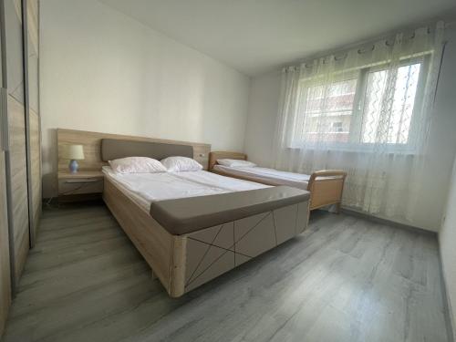 une chambre avec deux lits et une fenêtre dans l'établissement APPARTAMENT 85m2 A 5KM DE BASEL AU 1ERE ETAGE DANS UN CARTIER TRES CALME, à Huningue