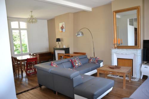un salon avec un canapé bleu et une cheminée dans l'établissement La ferme aux Hirondelles, proche Giverny, à Fontaine-sous-Jouy