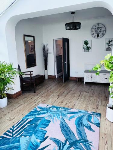 a living room with a rug on a wooden floor at Family & friends get together birthday hot tub in Porthcawl