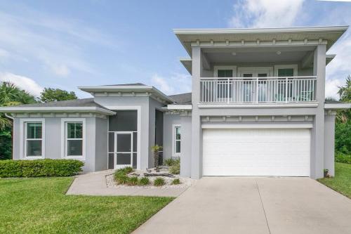 a large house with a white garage at Seaside Serenity -Private Pool with Beach Access in Melbourne Shores