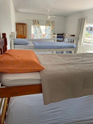 a group of four beds in a room at Casa Amarela Hostel in Guarapari