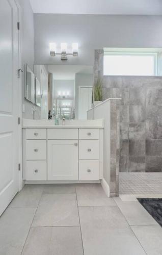 a white bathroom with a sink and a mirror at Seaside Serenity -Private Pool with Beach Access in Melbourne Shores