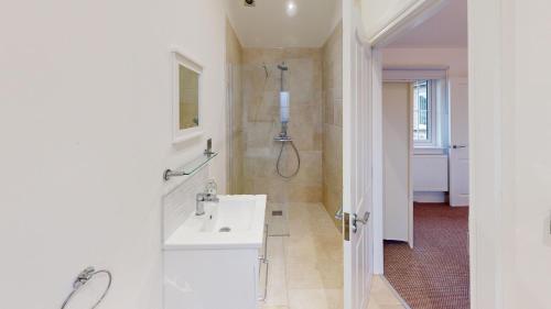 a white bathroom with a sink and a shower at Prospect Lodge at The Bay Filey, sleeps up to 6, and 2 dogs stay for free! in Filey