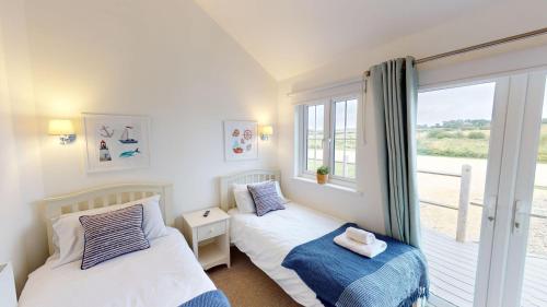 two beds in a room with a window at Prospect Lodge at The Bay Filey, sleeps up to 6, and 2 dogs stay for free! in Filey