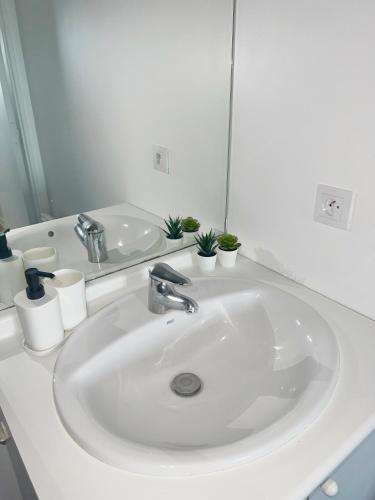 a white sink in a bathroom with a mirror at COSY NOISY Charmant 2 pièces entre Paris et DisneyLand in Noisy-le-Grand