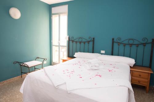 a bedroom with a white bed with flowers on it at Apartamento Babor Sun & Beach in Almerimar