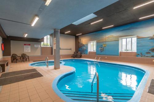 a large swimming pool in a hotel room at Au p'tit cocon sur le lac in Magog-Orford
