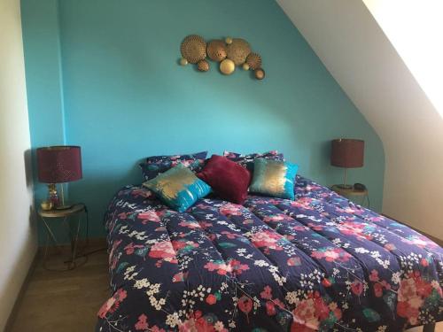 une chambre avec un lit avec un mur bleu dans l'établissement Villa Kerleven- 150m plage - Spa intérieur-piscine, à La Forêt-Fouesnant