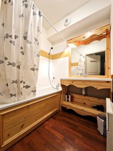 La salle de bains est pourvue d'un rideau de douche et d'un miroir. dans l'établissement Chalets De Florence - 2 pièces+cabine 4/6 personnes bien placé MAE-2928, à Modane