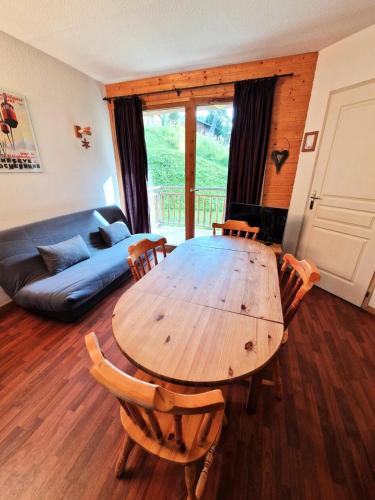 une table et des chaises en bois dans un salon dans l'établissement Chalets De Florence - 2 pièces+cabine 4/6 personnes bien placé MAE-2928, à Modane