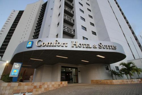 un bâtiment avec un panneau indiquant l'hôtel et les suites confortables dans l'établissement Comfort Hotel & Suites Natal, à Natal