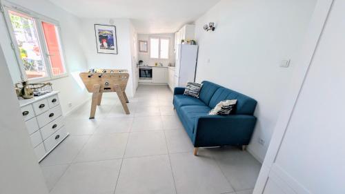 un salon avec un canapé bleu et une cuisine dans l'établissement grand studio indépendant, à Marseille