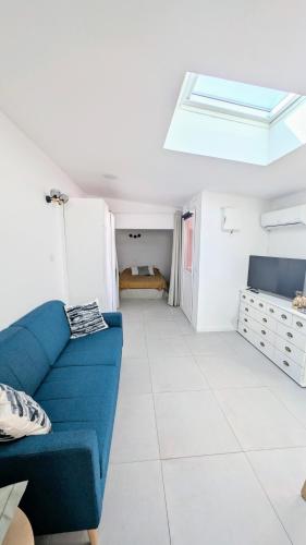 un salon avec un canapé bleu et une chambre dans l'établissement grand studio indépendant, à Marseille