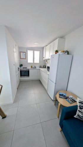 - une cuisine avec des appareils électroménagers blancs et un canapé bleu dans l'établissement grand studio indépendant, à Marseille