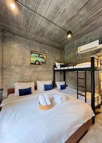 a bedroom with a large bed with two bunk beds at The Wishes Hotel at Chiangmai in Chiang Mai