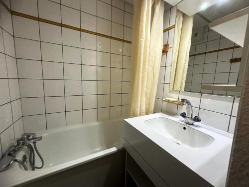 une salle de bain avec une baignoire blanche et un lavabo dans l'établissement Residence 3000 Bail - Studio pour 4 Personnes 31, à Mâcot La Plagne