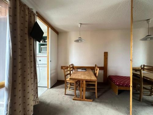 une salle à manger avec une table et une table et des chaises dans l'établissement Residence 3000 Bail - Studio pour 4 Personnes 31, à Mâcot La Plagne