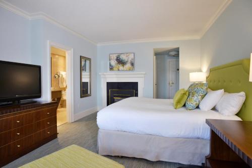 a bedroom with a bed and a flat screen tv at Queens Landing in Niagara on the Lake