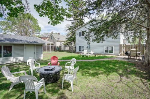 a yard with chairs and a table in the grass at Spacious Minneapolis Home Rental 8 Mi to Downtown in Minneapolis