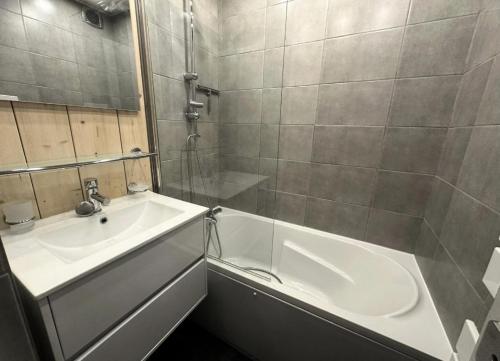 une salle de bain avec une baignoire blanche et un lavabo dans l'établissement Résidence Les Glaciers 3 - Studio pour 4 Personnes 28, à Mâcot La Plagne