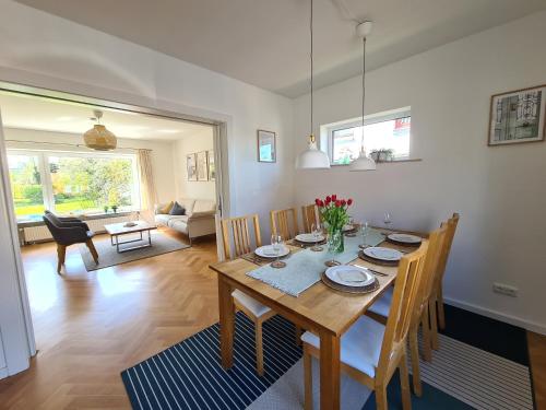 a dining room with a wooden table and chairs at Schönes Ferienhaus, bis 6 Pers, zentral gelegen in Heide