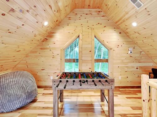 a wooden room with a foosball table in the attic at Fortune Mountain Retreat in McHenry