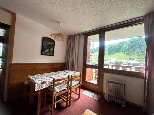 une pièce avec une table et une grande fenêtre dans l'établissement Résidence Carroley B - 2 Pièces pour 5 Personnes 04, à Mâcot La Plagne
