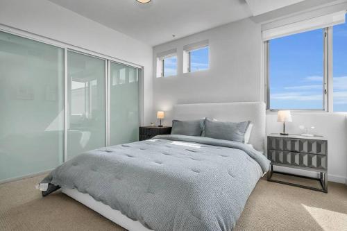 a bedroom with a large bed and large windows at Modern & chic in Heart of Downtown Santa Monica in Los Angeles