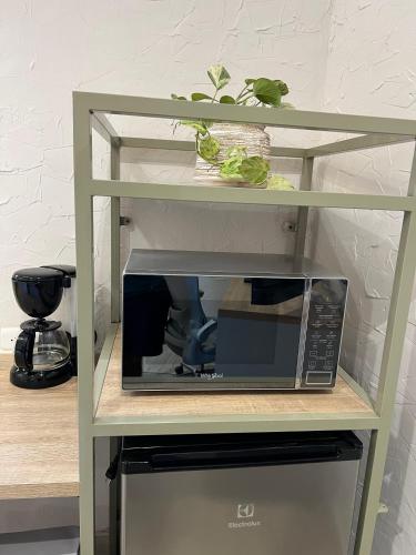 a microwave on a shelf next to a kitchen at Zentrico Boutique in Pereira