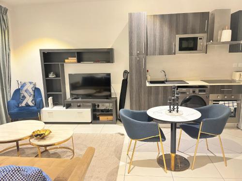 a living room with a table and chairs at Embassy Gardens Royal Suites Apartments in Accra