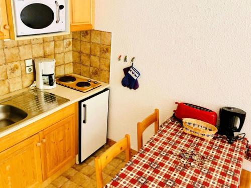 une cuisine avec une table et un réfrigérateur blanc dans l'établissement Résidence Val Coeur Bat A - Appartement 2 pièces 4 personnes agréablement situé à Val d'Isère à 350m du centre du village et à 300m des pistes MAE-3284, à Val dʼIsère